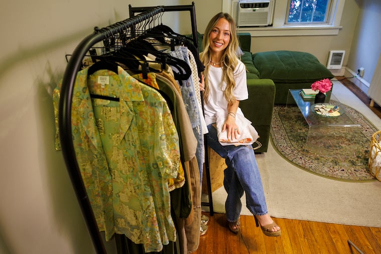 Angela Tate poses with a rack of gently used clothing she is selling through her Closet Happy Hour Instagram and Facebook pages. The 34-year-old Philadelphia resident is scaling back her nannying career to focus on building her resale side hustle into a full-blown online business.