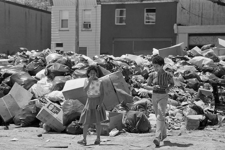 Marybel Colon, 10, of Philadelphia holds her mouth and nose while cutting through a temporary dumpsite in her neighborhood in Philadelphia, July 15, 1986, due to the strike by municipal workers.
