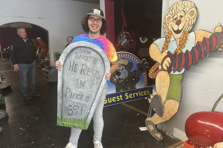 Ed Frischkorn, 30, holds the gravestone from the train ride at the now-defunct Gillian's Wonderland Pier. He purchased the piece last month at Obnoxious Antiques in Burlington.