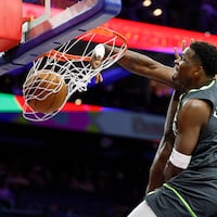 Timberwolves guard Anthony Edwards dunks the basketball past Sixers center Adem Bona in the first quarter.