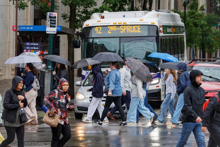Pedestrians with umbrellas out walking walking near Independence Mall Wednesday. It's been a wet, chilly period in Philly.