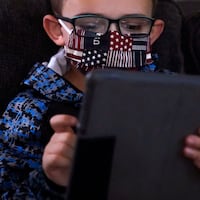 A kindergartener takes part in distance learning in Massachusetts during the COVID-19 outbreak in October 2020. Threats to funding of public broadcasters increses the difficulty of planning for the next education crisis, writes Yoni Greenbaum. 