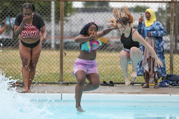 From left, Lisa Kidd, Keyana Mason, and Julianna Cosme jump in together on the first day of the pool season in Philadelphia at the recently renamed Tiffany Fletcher Recreation Center (formerly Mill Creek) in West Philadelphia on Wednesday, June 14, 2023. Philadelphia’s public pools are opening this week, and will continue to open on a rolling basis through mid-July.