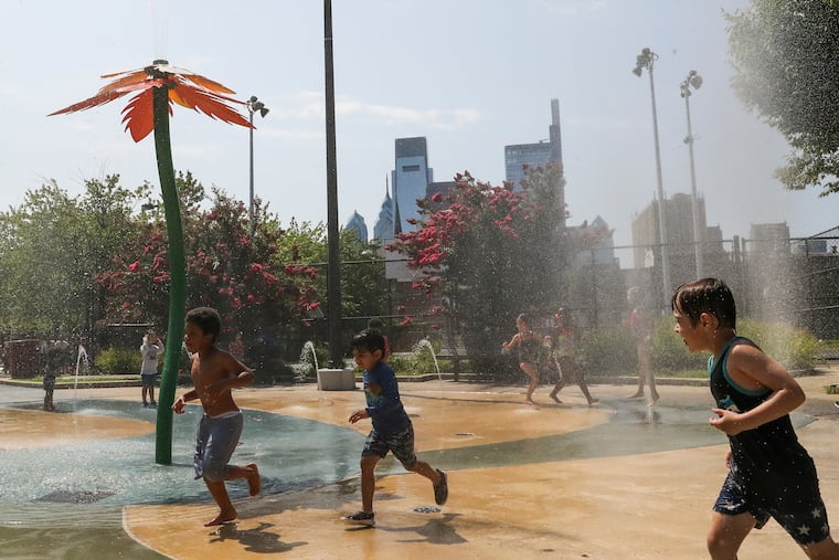 The Philly skyline can be seen as kids cool off at the spray park inside Roberto Clemente Park during August heat wave. It's about to get mighty hot around here.n Friday, Aug. 13, 2021. A heat wave is currently gripping the Philadelphia region.
