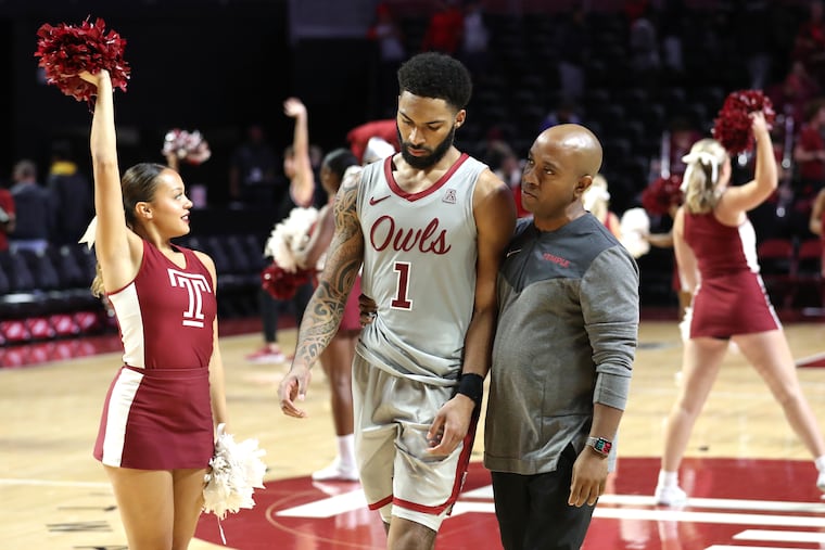 Temple assistant coach Chris Clark consoles Damian Dunn after an overtime loss to Vanderbilt in 2022.