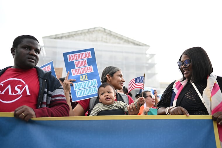 Olga Urbina holds her son, Ares Webster, as people gather outside the Supreme Court in May. 