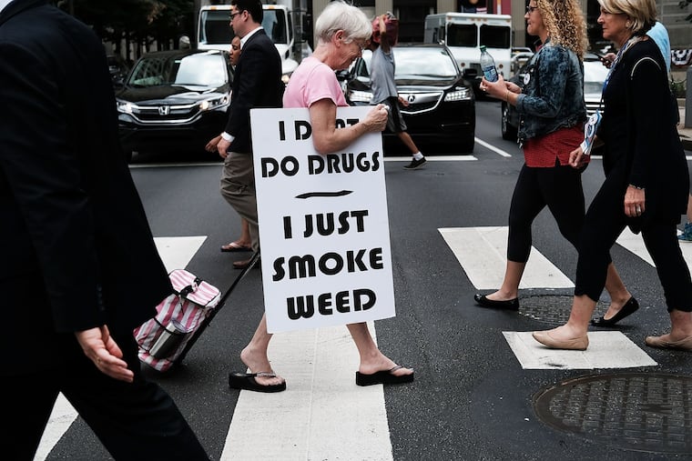 A woman walks with a sign supporting legalizing marijuana during the Democratic National Convention in 2016 in Philadelphia.