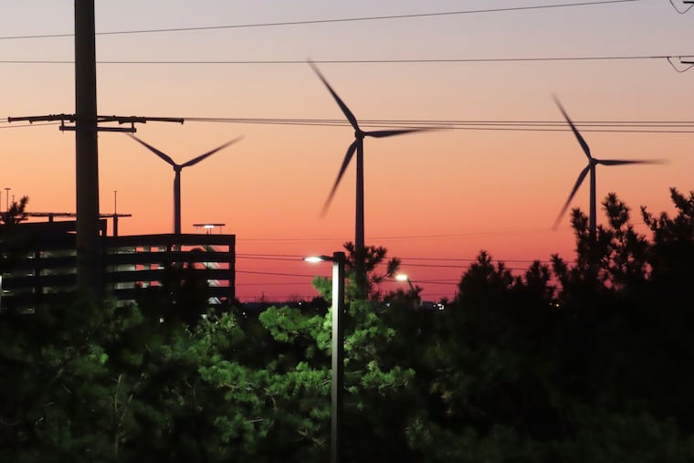 The sun sets behind spinning land-based wind turbines in Atlantic City, N.J., on Dec. 13, 2023. (AP Photo/Wayne Parry)