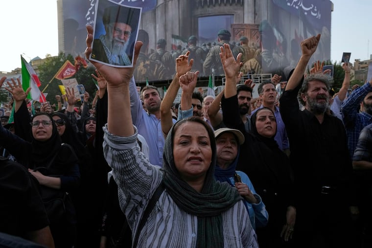 Protesters in Tehran chant slogans as one of them holds up a poster of the Iranian Supreme Leader Ayatollah Ali Khamenei in a protest following the U.S. attacks on nuclear sites in Iran on Sunday.