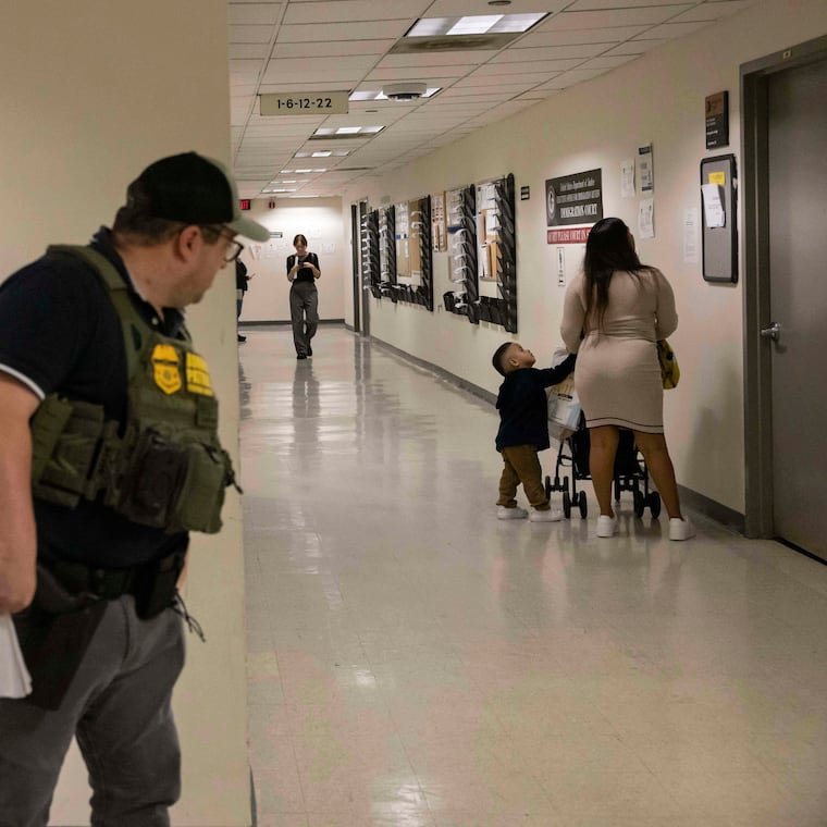 A border patrol agent looks at a family outside an immigration courtroom at the Jacob K. Javits Federal Building in New York, Tuesday, June 10, 2025. 