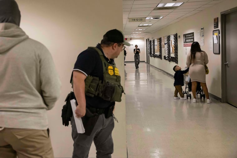 A border patrol agent looks at a family outside an immigration courtroom at the Jacob K. Javits Federal Building in New York, Tuesday, June 10, 2025. 