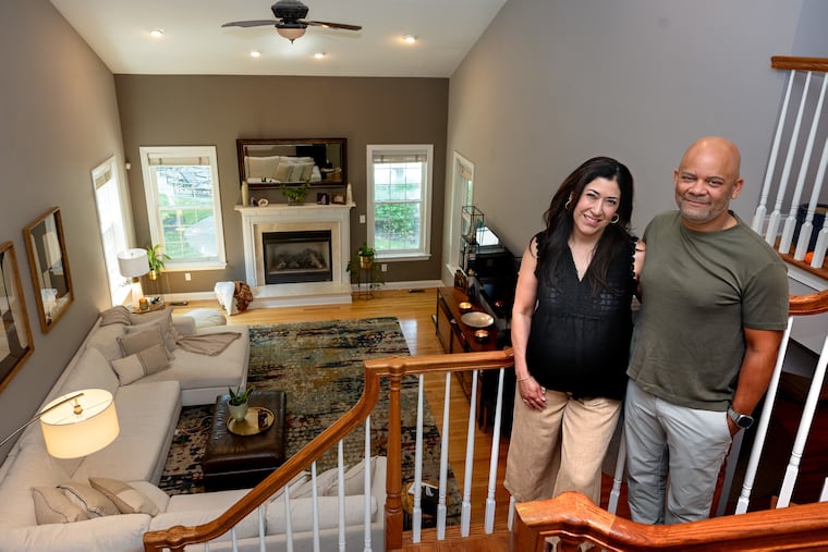 Mick Weeks and Julie Alvarado Weeks pose on the staircase overlooking the living room of their Moorestown home.