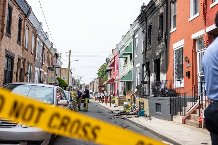 Firefighters at the scene of a house fire that broke out in Strawberry Mansion, where a woman and two children died on June 13.