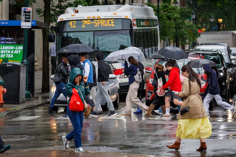Pedestrians walking in the rain near Independence Mall in what has become a common scene after months of dyrness. 