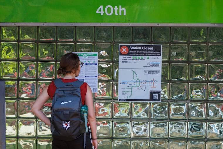 A commuter reads signs in 2024 as SEPTA trolleys enter tunnel at the 40th and Baltimore. It's time again for the Trolley Blitz.