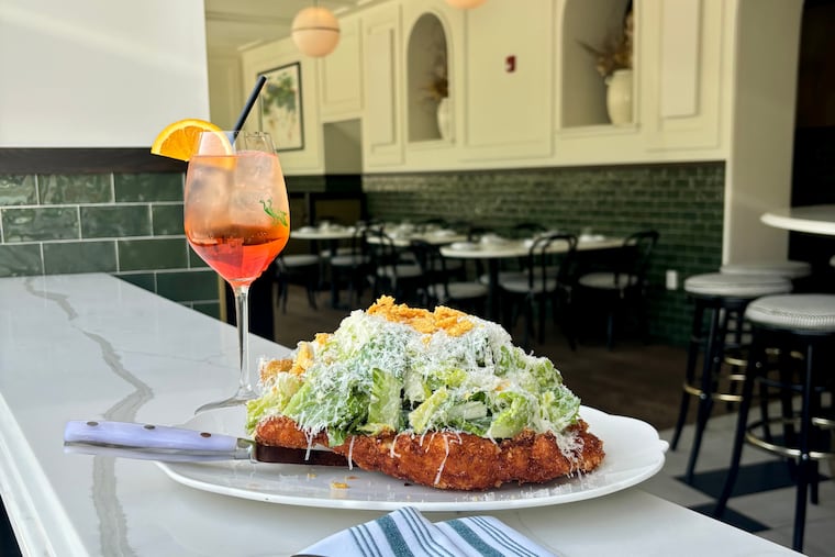 The Caesar salad with a chicken cutlet at Carina Sorella, with one of the three spritz cocktails offered at the bar.